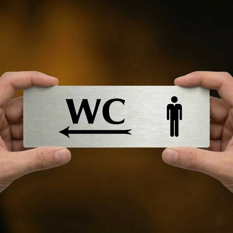 WC muži vlevo, 200x66mm, stříbrná popiska s ozdobou uprostřed